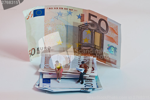 Image of Miniature people in action with euro banknotes