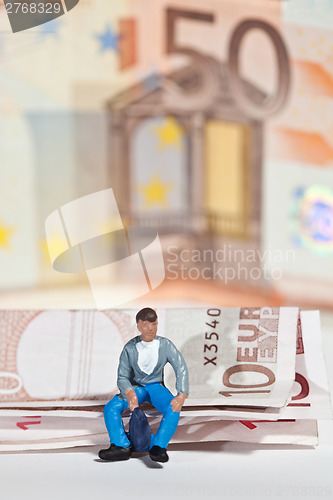 Image of Miniature people in action with euro banknotes