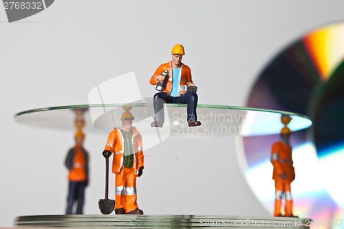 Image of Miniature people in action with CDs