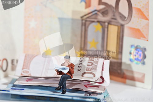 Image of Miniature people in action with euro banknotes