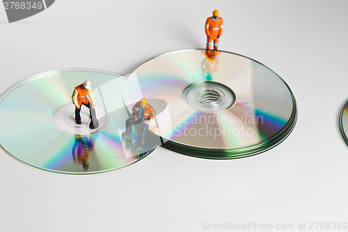 Image of Miniature people in action with CDs