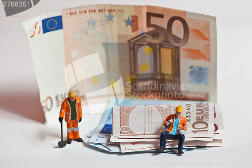 Image of Miniature people in action with euro banknotes