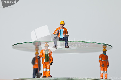 Image of Miniature people in action with CDs