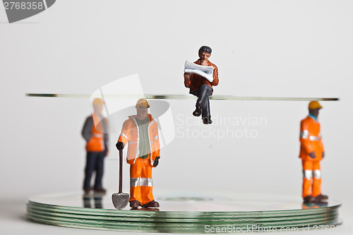 Image of Miniature people in action with CDs