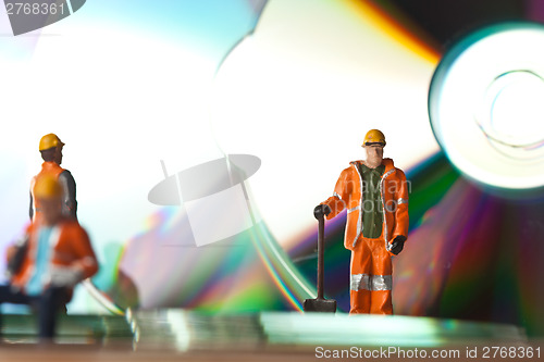 Image of Miniature people in action with CDs