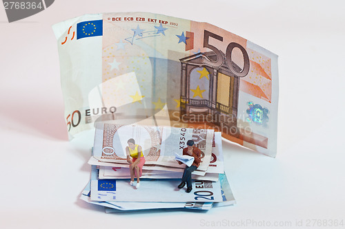 Image of Miniature people in action with euro banknotes