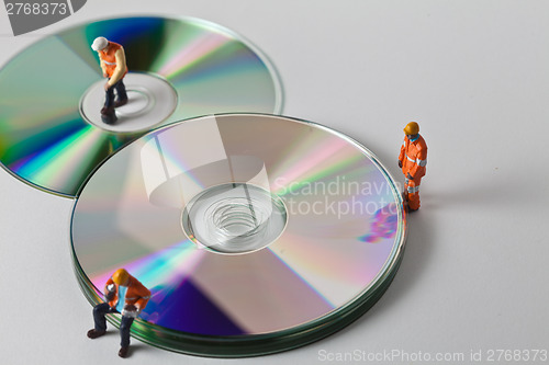 Image of Miniature people in action with CDs