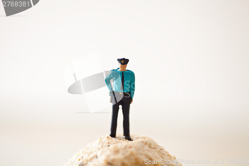 Image of Miniature policeman on a stack of sand 