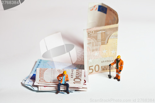 Image of Miniature people in action with euro banknotes