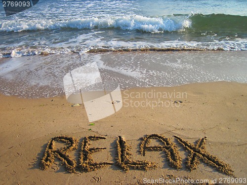 Image of relax - text in the sand 