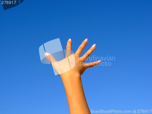 Image of Female hand on a background of the blue sky