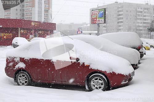 Image of The cars brought by snow, stand on a road roadside.