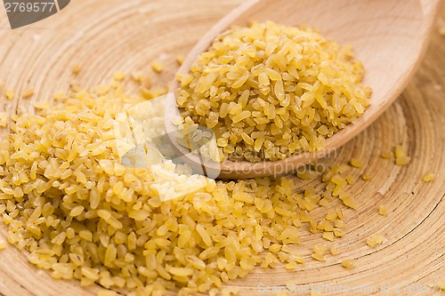 Image of bulgur wheat in wooden spoon