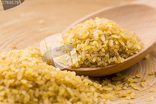 Image of bulgur wheat in wooden spoon