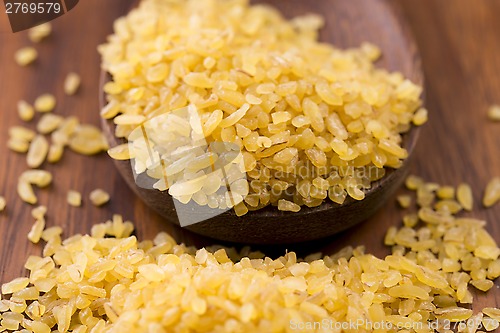 Image of bulgur wheat in wooden spoon