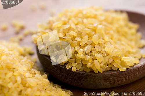 Image of bulgur wheat in wooden spoon