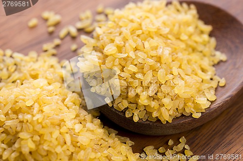 Image of bulgur wheat in wooden spoon