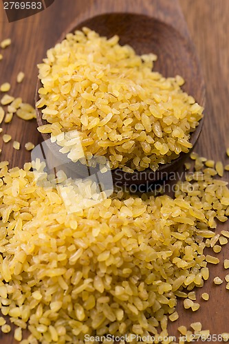 Image of bulgur wheat in wooden spoon