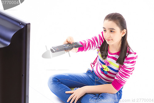 Image of Happy little girl laying down and watching tv