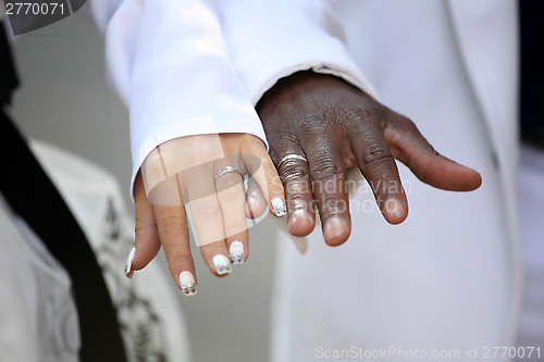 Image of Causian and African-American couple holding hand with ring