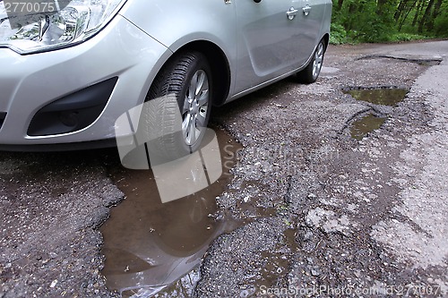 Image of Damaged road full of cracked potholes in pavement