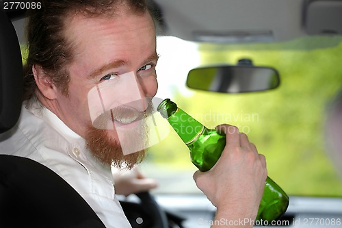 Image of Drunk man in car with a bottle beer