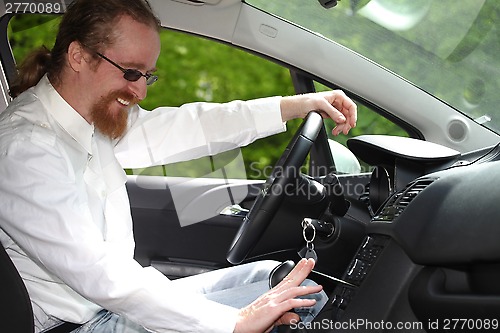 Image of driver with CD, playing music in the car