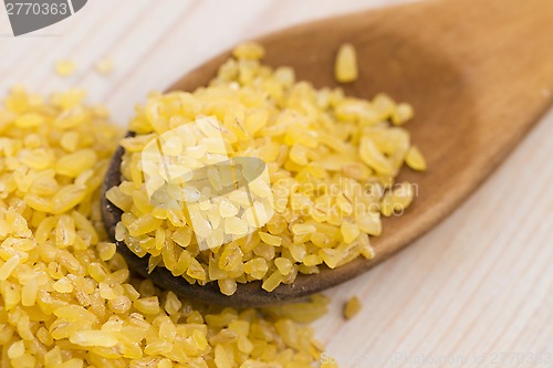 Image of bulgur wheat in wooden spoon