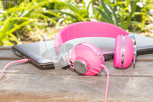 Image of Vivid colorful pink headphones and laptop