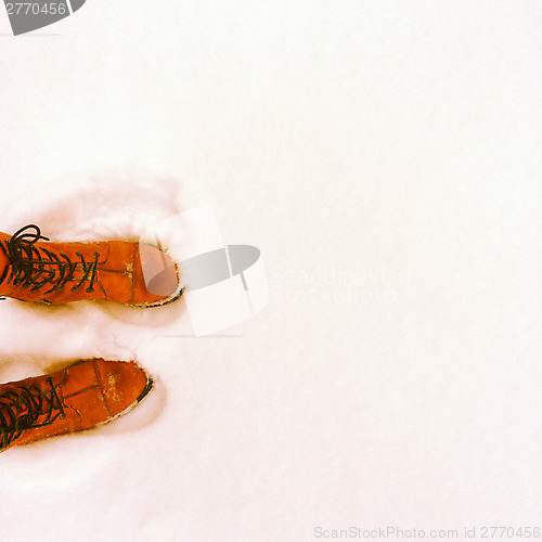 Image of Person in orange boots standing in the snow