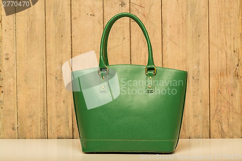 Image of green purse on wood background