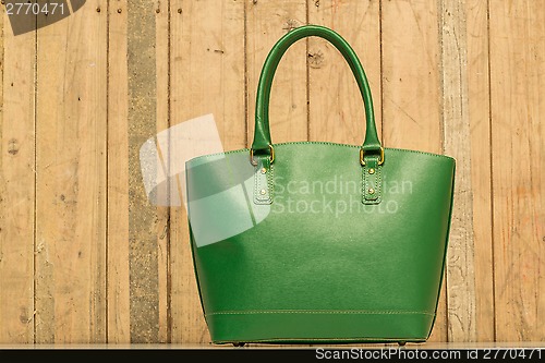 Image of green purse on wood background