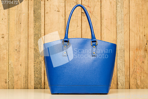 Image of blue purse on wood background