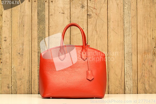 Image of red purse on wood background