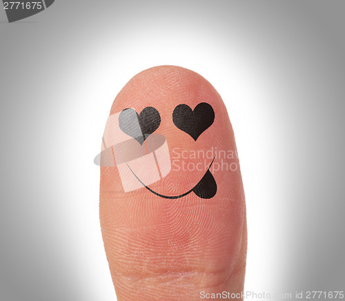 Image of Female thumbs with smile face on the finger