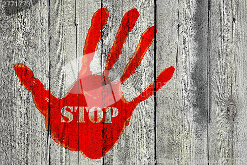 Image of Handprint with the word ''Stop'' on old wooden fence background