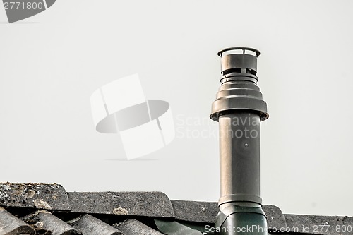 Image of Metal chimney on the top a roof