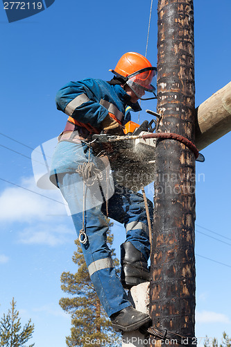 Image of Electrician working on electricity pylon chainsaw 