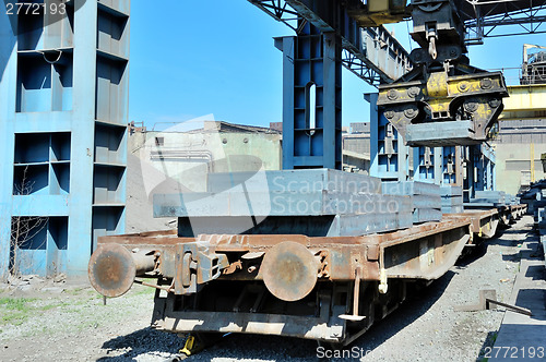 Image of crane loading steel stack 
