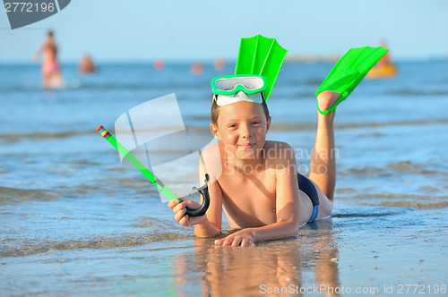 Image of  boy with  swimming goggles, snorkel swimming and flippers 