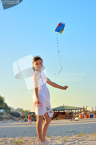 Image of young girl flying a kite on the beach