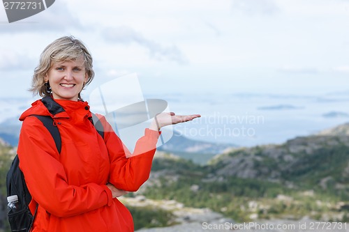 Image of Happy woman tourist showing blank copy space on the palm
