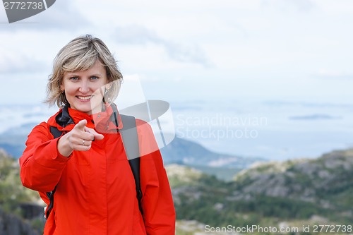Image of Happy woman tourist pointing finger at you