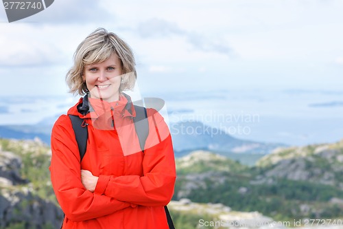 Image of Portrait of happy woman tourist standing smiling outdoors