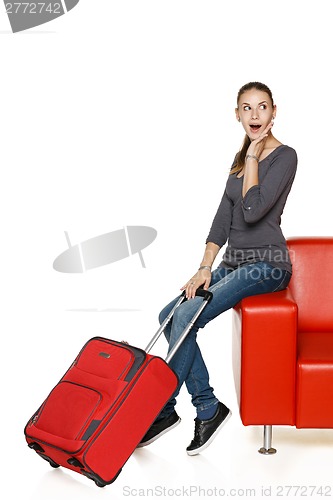 Image of Happy female on sofa with suitcase