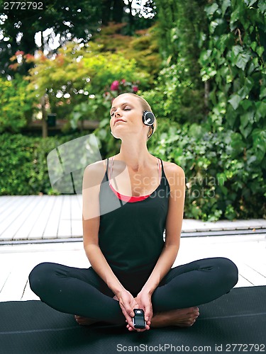 Image of woman in earphones doing yoga rt