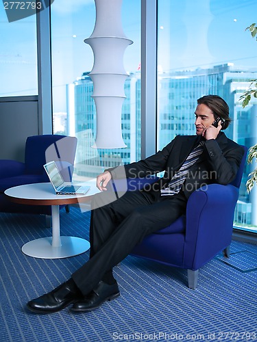 Image of Business man with laptop in office L