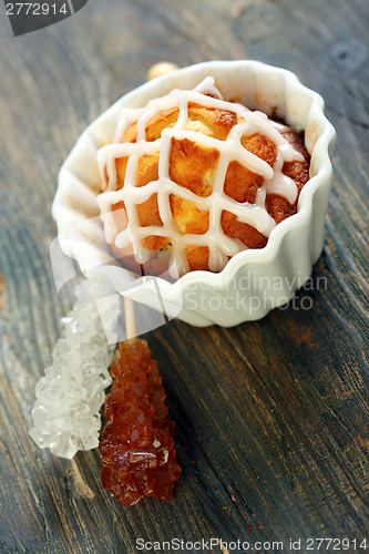 Image of Cupcake with icing and sugar sticks.