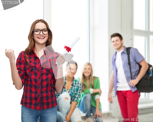 Image of smiling female student in eyeglasses with diploma