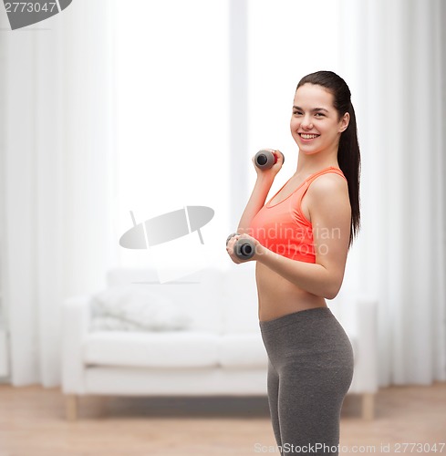 Image of young sporty woman with light dumbbells